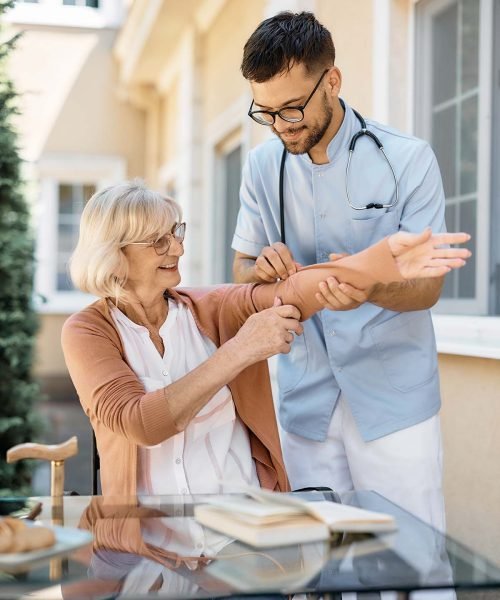 young-caregiver-assisting-senior-woman-on-the-nurs-KV4JSC7.jpg